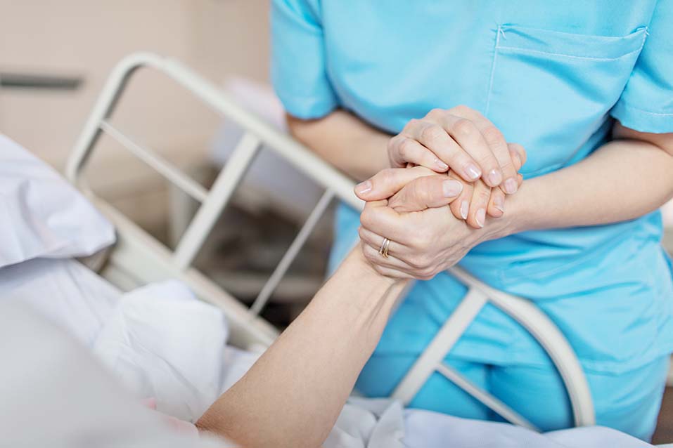 Nurse holding hand of a patient